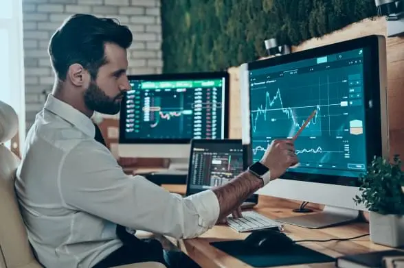 Verdifjord trading dashboard with a user analyzing live market charts on desktop monitors